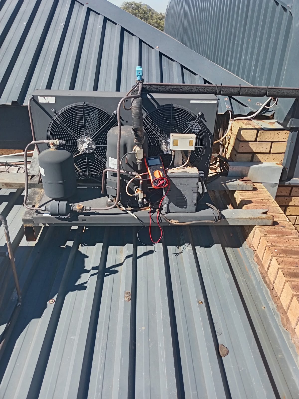Refrigeration condenser unit mounted on a tiled roof