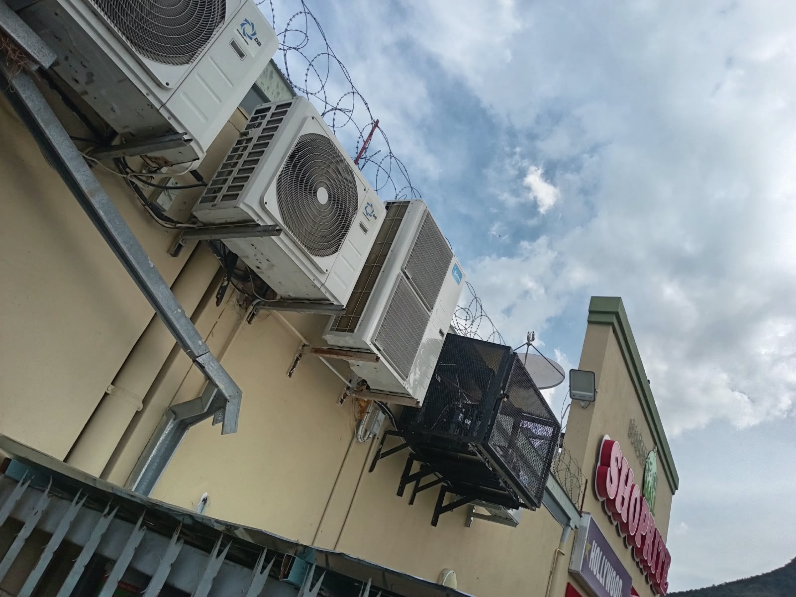 Row of aircon condenser units mounted above a shop front